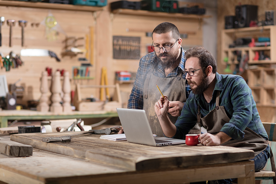 2 shop floor workers looking at pc