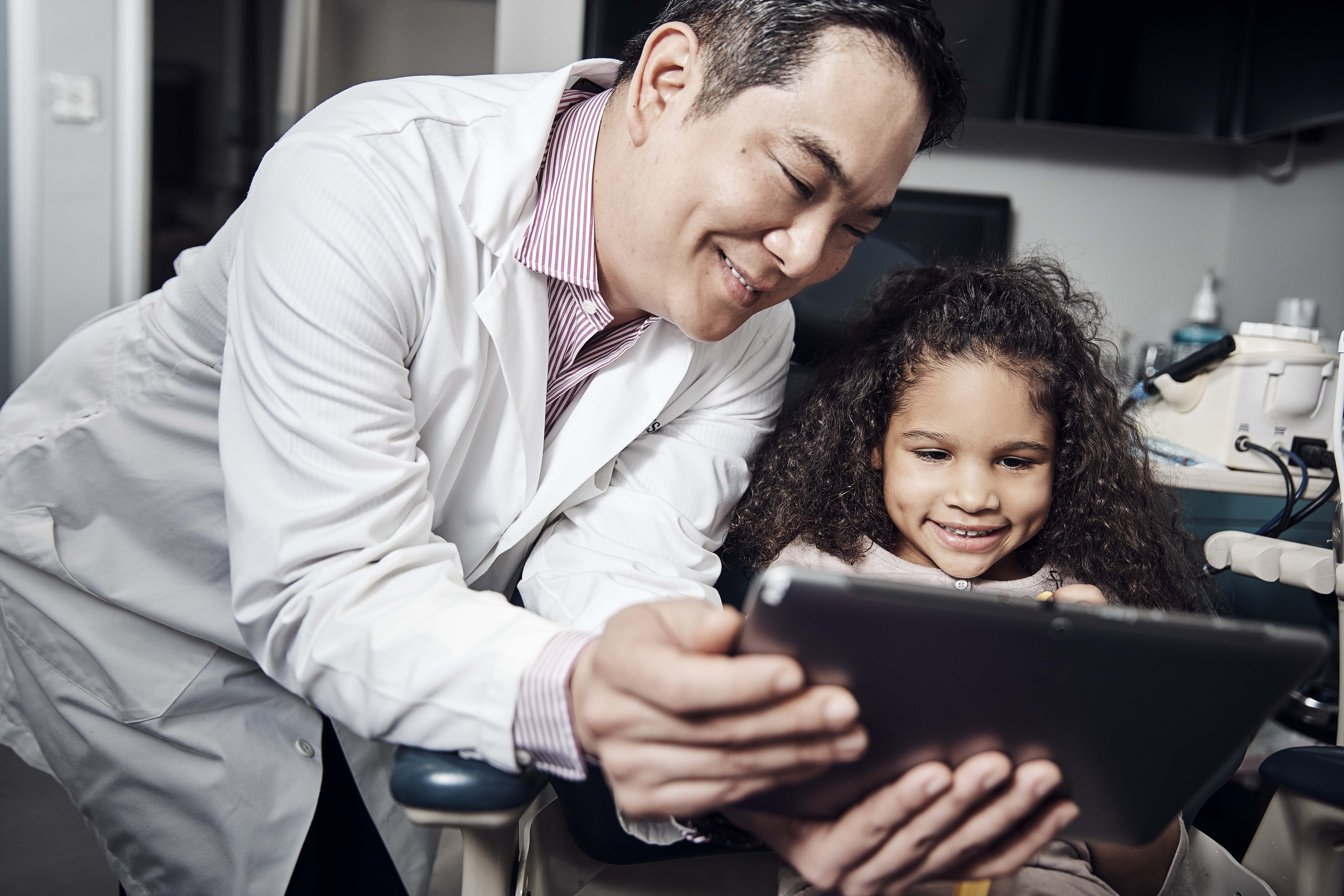 Dentist reviews dental x-ray with young patient