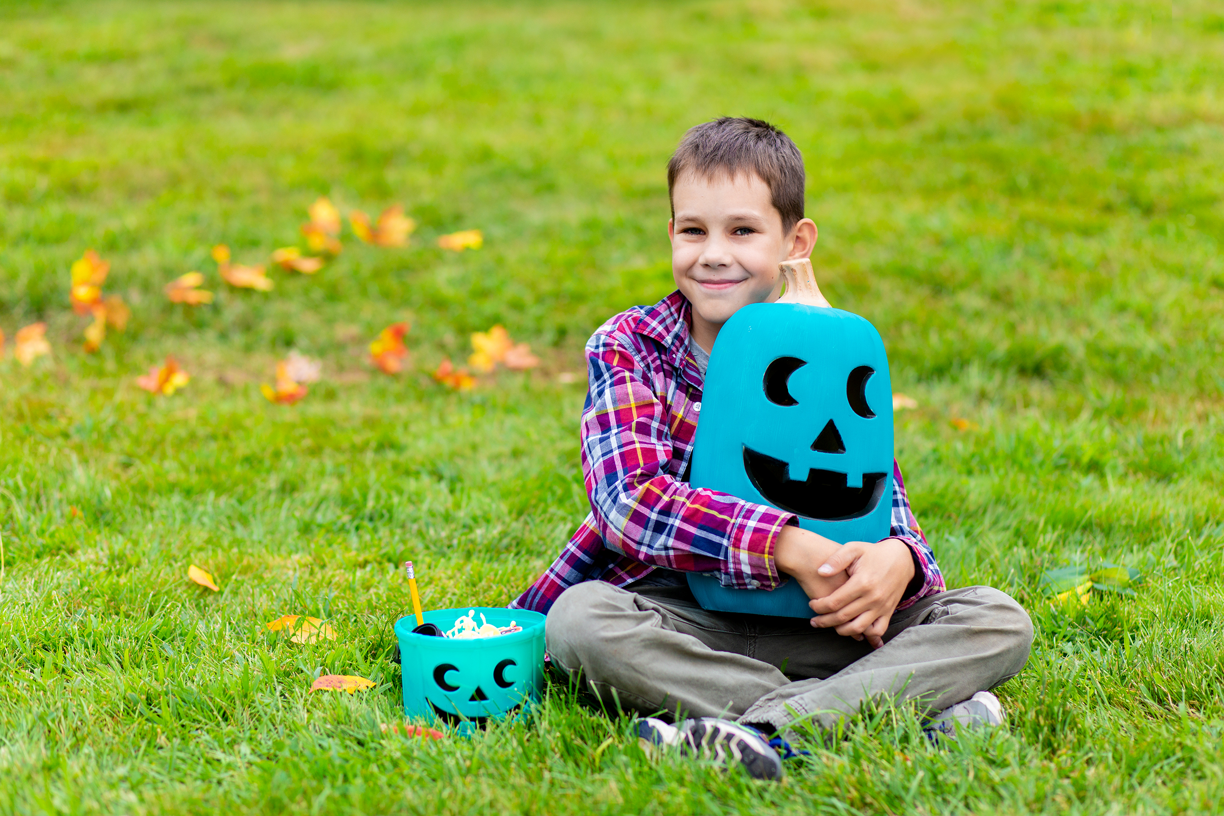 Boy with teal bucket and teal pumpkin